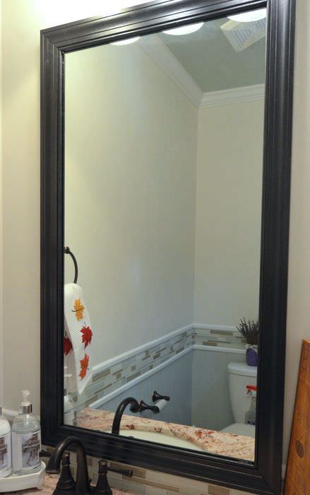Черная рамка из плинтуса на зеркале в ванной комнате
